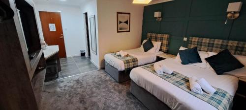 a hotel room with two beds and a bathroom at MacDonald Hotel & Cabins in Kinlochleven