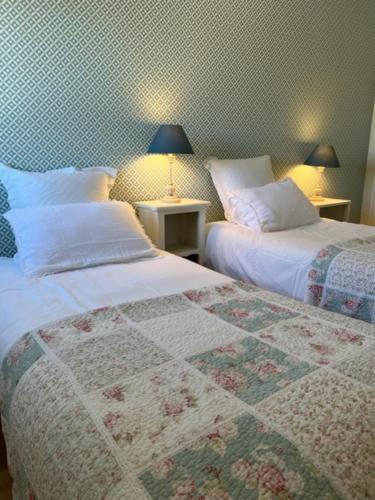 a bedroom with two beds and two tables with lamps at Ma Rosalie in Le Crotoy