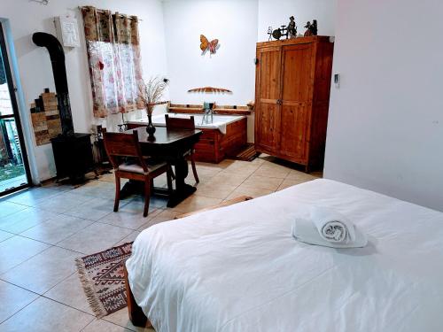 een slaapkamer met een bed, een bureau en een tafel bij SHIR HACHORESh in Shomera