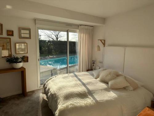 - une chambre avec un lit et une fenêtre avec une piscine dans l'établissement Villa K Maison archi avec piscine 15 mn PUY du FOU, à Cholet