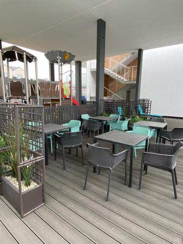 a restaurant with tables and chairs on a deck at Kapitańska 16C31 in Grzybowo