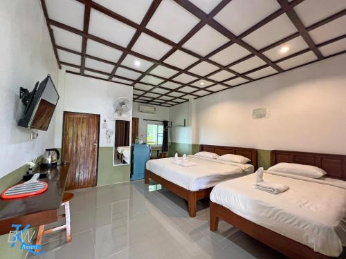 una camera d'albergo con due letti e una tv di Baan Khue Wieng Resort a Mae Sariang