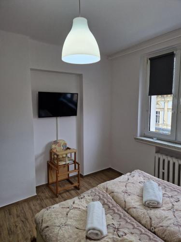 1 dormitorio con 2 camas y lámpara grande en Apartament w Centrum, en Prudnik