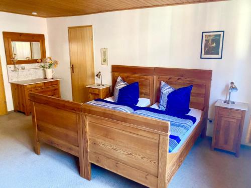 a bedroom with a large wooden bed with blue pillows at Ferienwohnung Peters in Trebel