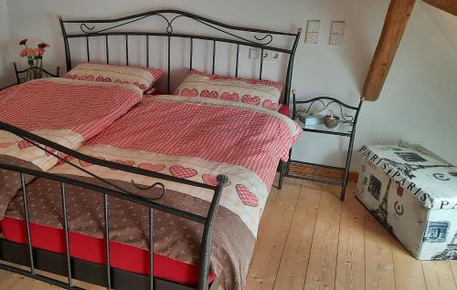 1 dormitorio con cama de metal con sábanas rosas en Ferienwohnung Bodensee Haus Franziskus, en Herdwangen-Schönach
