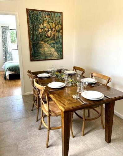 a dining room with a wooden table and chairs at Wattle Cottage in Mandurama