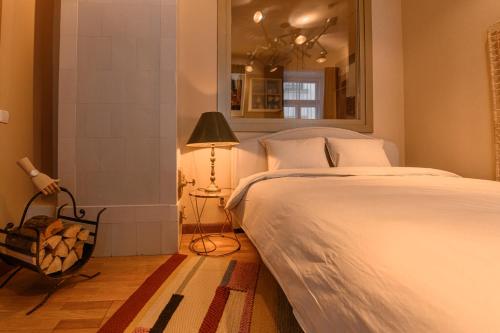 a bedroom with a bed and a lamp and a mirror at St.Jacobs's apartments Old Town Riga in Rīga
