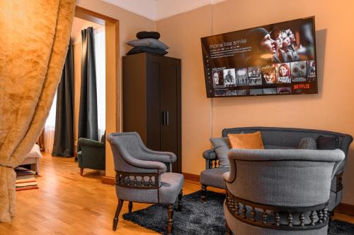 uma sala de espera com cadeiras e uma televisão de ecrã plano em St.Jacobs's apartments Old Town Riga em Riga