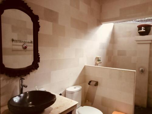 ein Bad mit einem schwarzen Waschbecken und einem WC in der Unterkunft Di Abian Villas in Amed