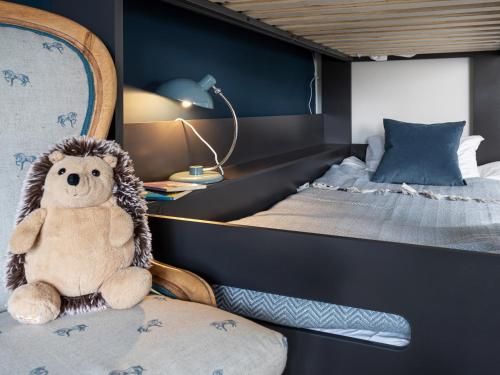 a stuffed animal sitting on a chair in a bedroom at Longlands Farm Cottage in Grange Over Sands