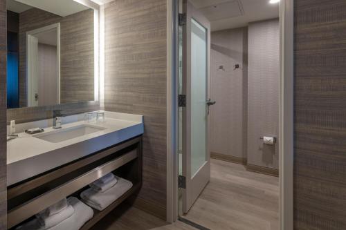 uma casa de banho com um lavatório e um espelho em Wichita Marriott em Wichita