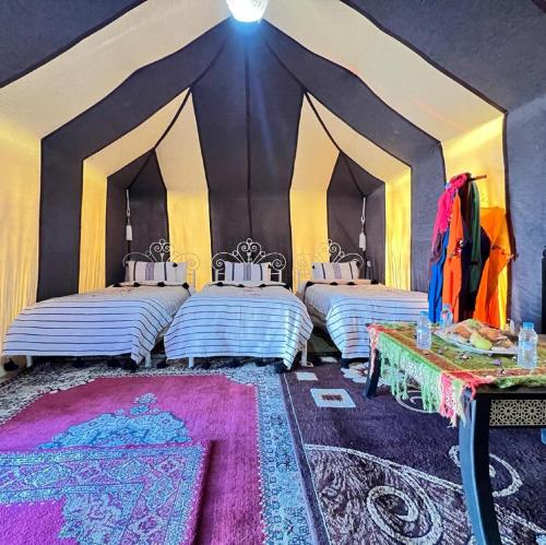 a room with three beds in a tent at Bivouac Draa in Zagora