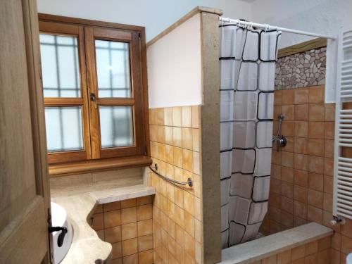 a bathroom with a shower and a toilet and a window at Residenza di Campagna Seranile in Dorgali