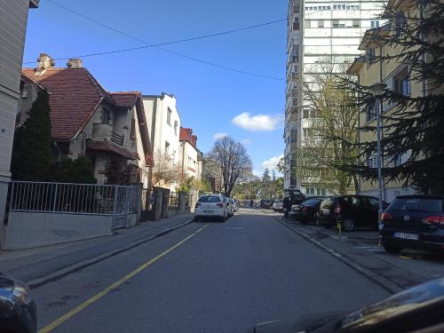 a white car driving down a street with buildings at Milash in Karaburma
