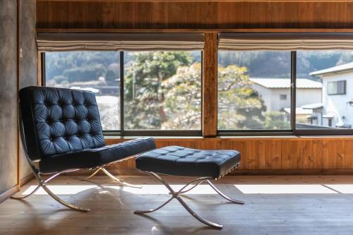 a black chair sitting in front of a window at MITSU-House in Nishikatsuracho