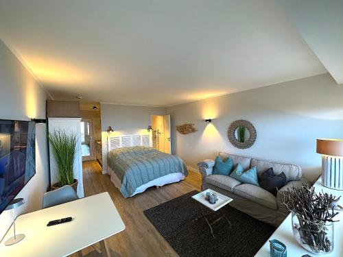 ein Wohnzimmer mit einem Bett und einem Sofa in der Unterkunft KNYD'S am MEER in Wenningstedt-Braderup