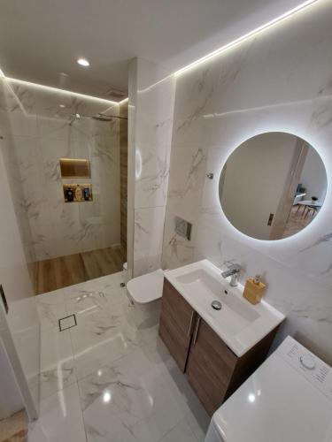 Baño blanco con lavabo y espejo en Luxury Suite Patras (1), en Patra
