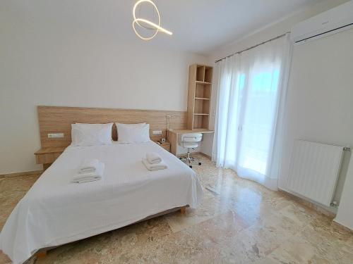 1 dormitorio con 1 cama blanca y 2 toallas en Luxury Suite Patras (1), en Patra