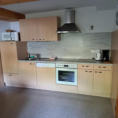 a kitchen with wooden cabinets and a stove top oven at Haus Bacher in Tux