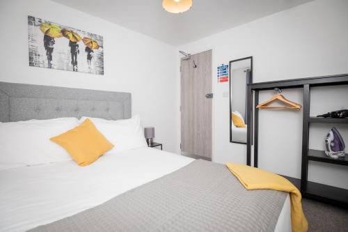 una camera con un letto bianco e un cuscino arancione di Self containted 1 Bed modern apartment- Meters from Beach a Great Yarmouth