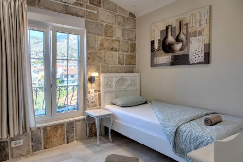 Habitación pequeña con cama y ventana en Apartments Villa Mike, en Mostar