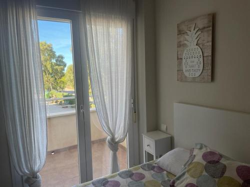 1 dormitorio con 1 cama y puerta corredera de cristal en Cabo de Gata Oasis Retamar II, en Almería