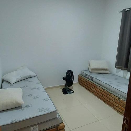 a room with two beds and a fan in it at Casa com picina in São José da Coroa Grande