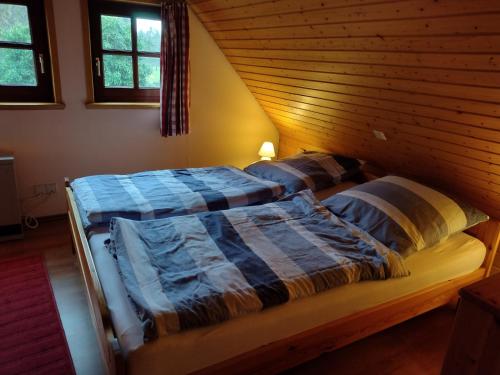 a bed in a room with a wooden ceiling at Ferienhaus Rodewald in Bomlitz