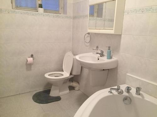 uma casa de banho branca com um WC e um lavatório em Apartamento City em Košice