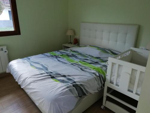 1 dormitorio con 1 cama con cabecero blanco en Casa de campo entre dos parques naturales, en Igorre