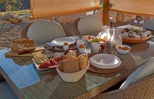 a table with bread and plates of food on it at Casa LIMA in Viñuela