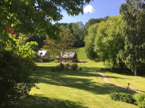 a house in the middle of a field with trees at Les Fermes de Florence Bien être et nature in Les Champeaux