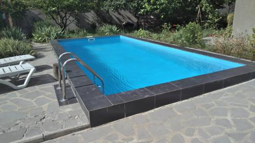 una piscina con un banco al lado en Cozy cottage near Tbilisi, en Kubriantkari