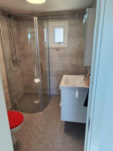 een badkamer met een douche, een toilet en een wastafel bij Strandskatan 102 in Halmstad