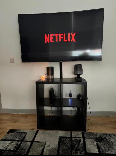 einen Fernseher mit einem Netflix-Schild an der Wand in der Unterkunft Modern flat in Maidstone in Kent