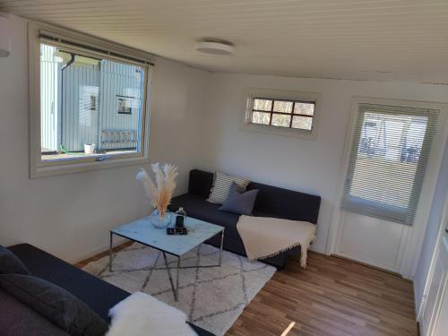 uma sala de estar com um sofá e uma mesa em Strandskatan 102 em Halmstad