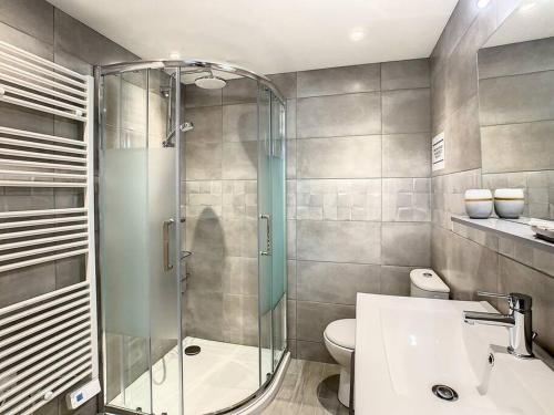 a bathroom with a shower and a toilet and a sink at Happy HOME in Cierp