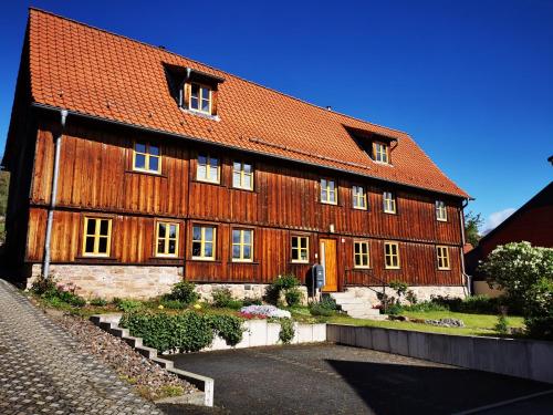 ein großes Holzgebäude mit rotem Dach in der Unterkunft Haselnuss in Ilsenburg