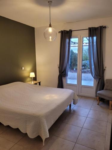 ボーム・ド・ヴニーズにあるMas du Tilleulのベッドルーム1室(ベッド1台、窓、椅子付)