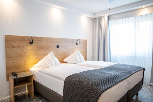 a hotel room with a large bed and a window at Hotel Sursee in Sursee