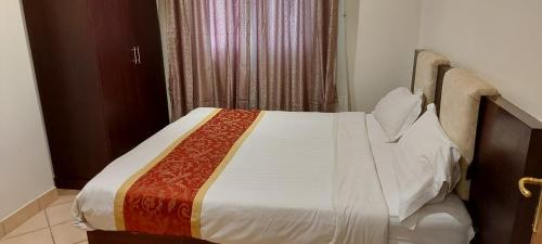 a bedroom with a large bed with white sheets at تالين الجامعي in Riyadh