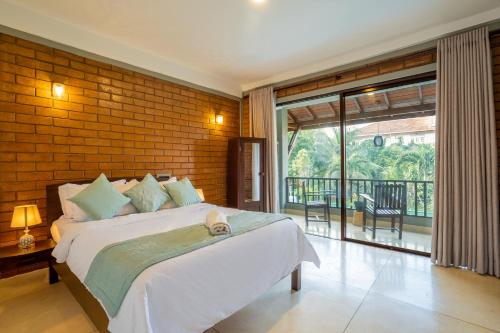 a bedroom with a bed with a brick wall at Anura's Elephant in Beruwala