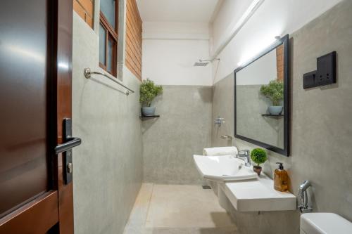 a bathroom with two sinks and a mirror at Anura's Elephant in Beruwala