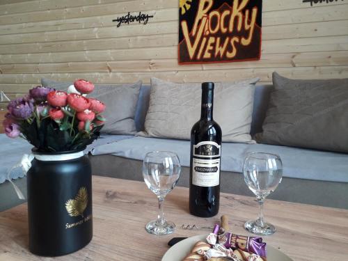 a bottle of wine sitting on a table with glasses at Rocky Views in Stepantsminda