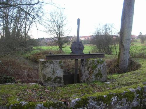 a stone monument in a field next to a tree at Le Floyon (avec piscine) in Florennes