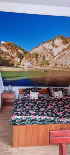a bedroom with a bed with a painting on the wall at Apartament Nad Dunajcem in Sromowce Niżne