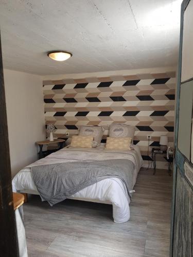 - une chambre avec un grand lit et un mur rayé dans l'établissement La maisonnette 301, à Saint-Ouen-en-Belin