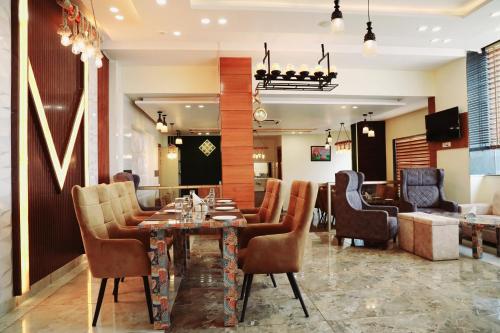 a dining room with a table and chairs at Hotel Vasdaa Grand in Dehradun