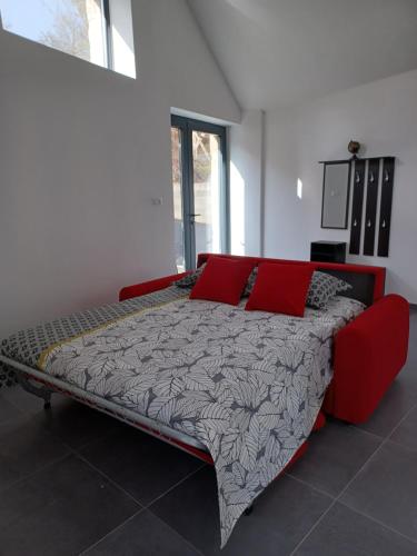 a large bed with red pillows in a room at Le Loft in Barjac