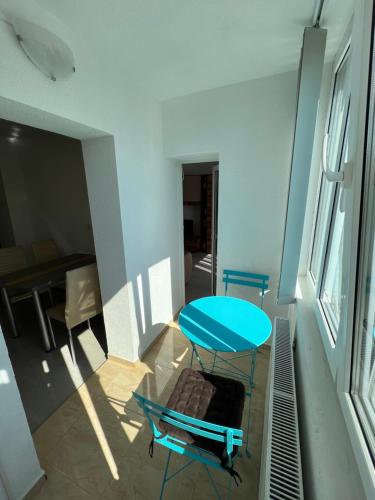 un tavolo blu e una sedia in una stanza di Nicola Flat Mall a Arad